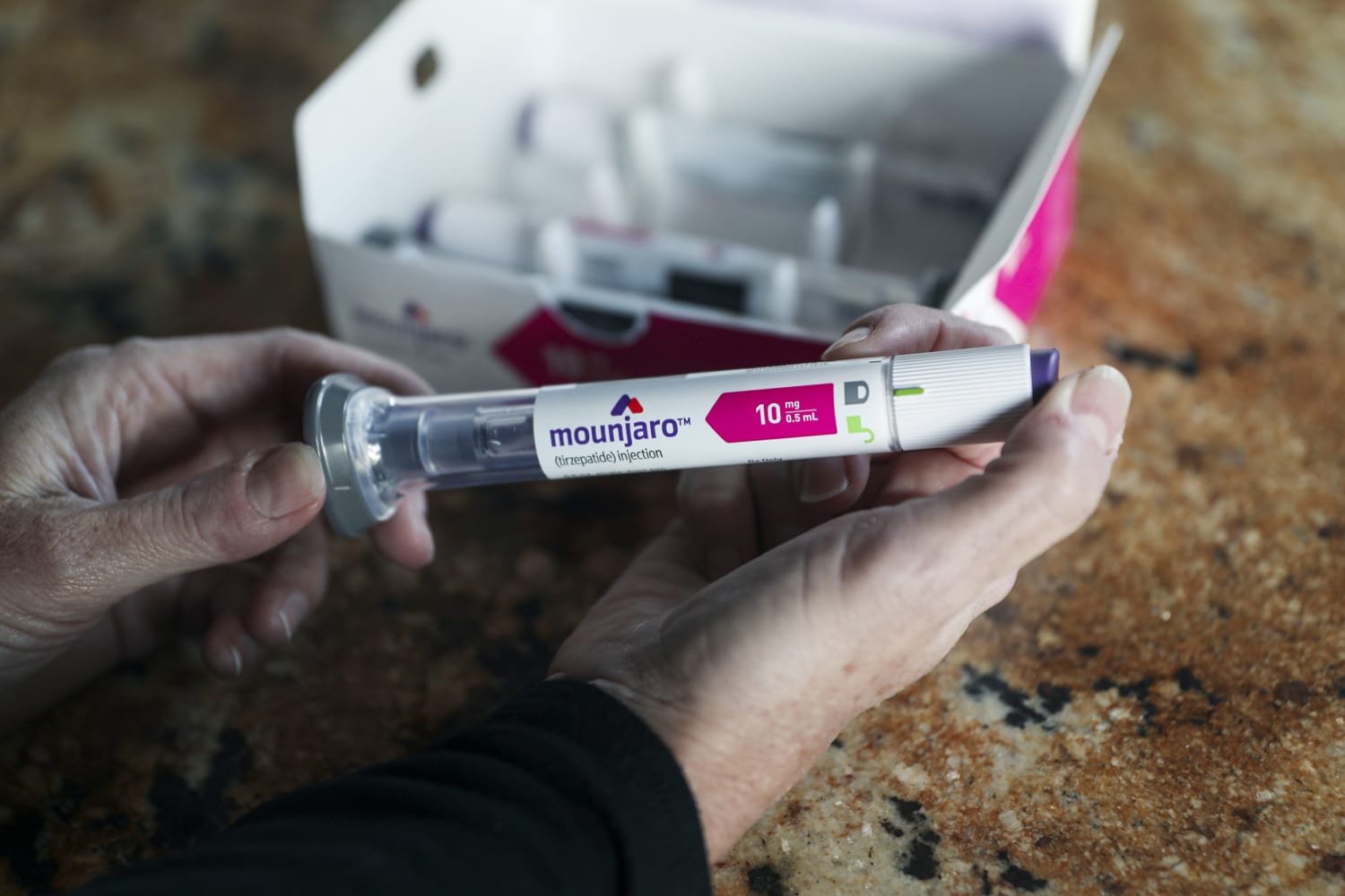 Man dient zichzelf Mounjaro 2,5 mg injectie toe met pen