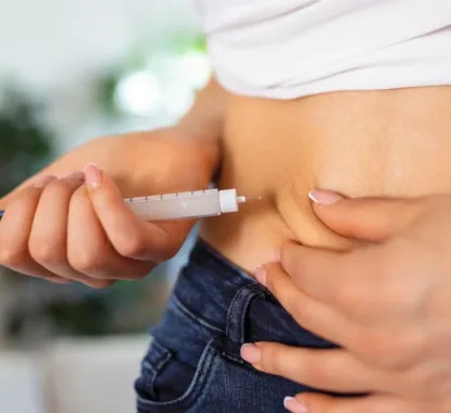 Vrouw injecteert retatrutide-pen in buik om af te slanken zonder doktersvoorschrift